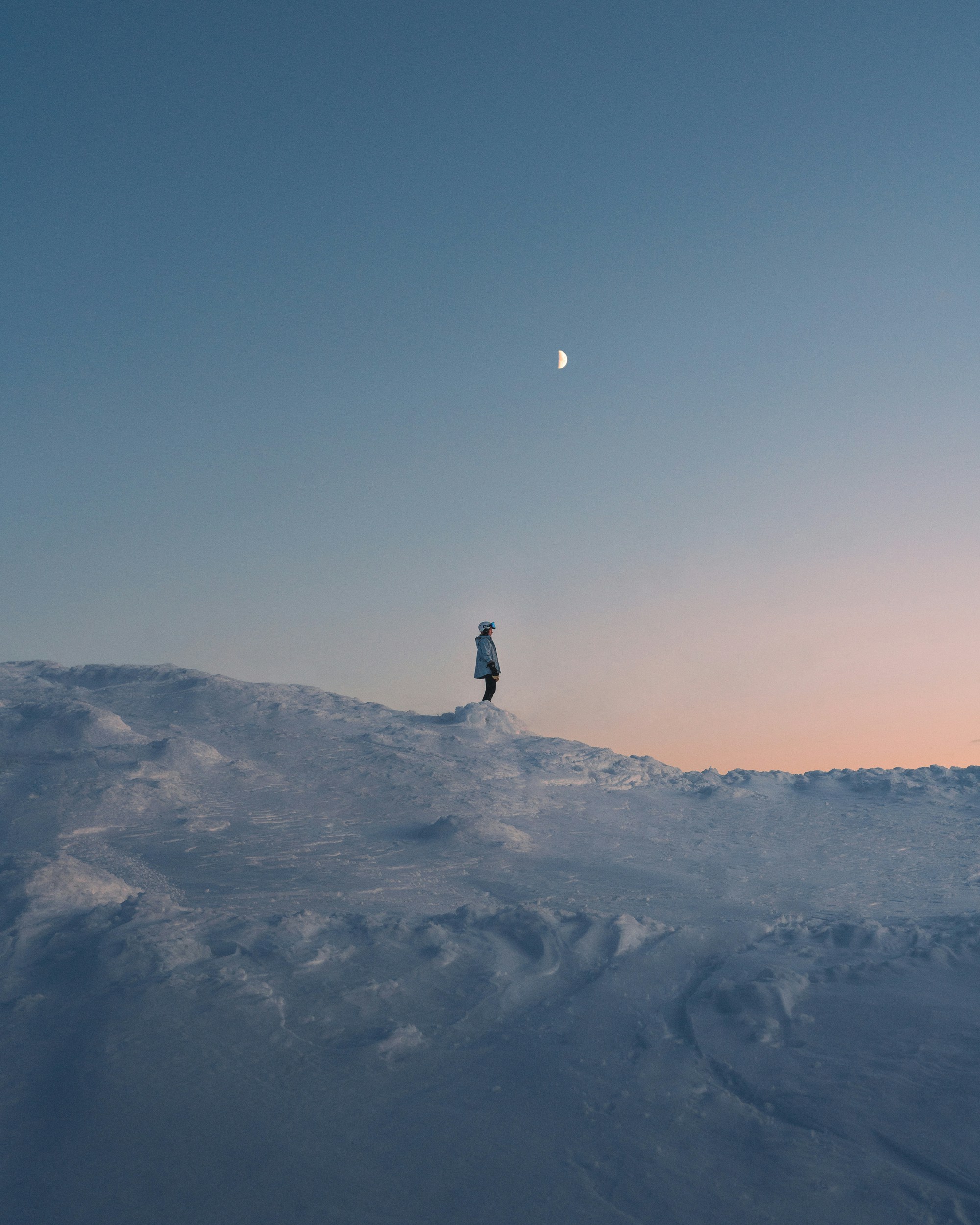Skier on snowy ridge at sunset