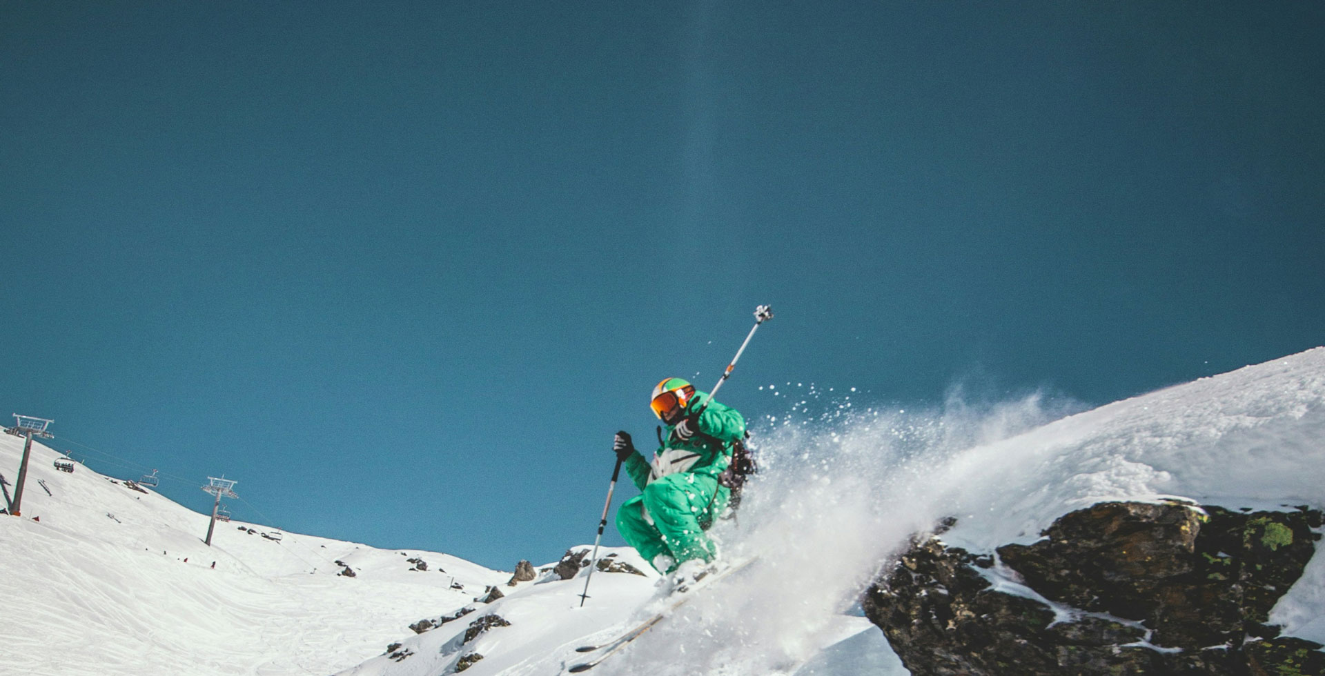 Skier on snowy ridge at sunset